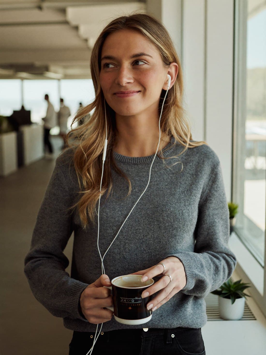 An employee smiling on a coaching call by an office window